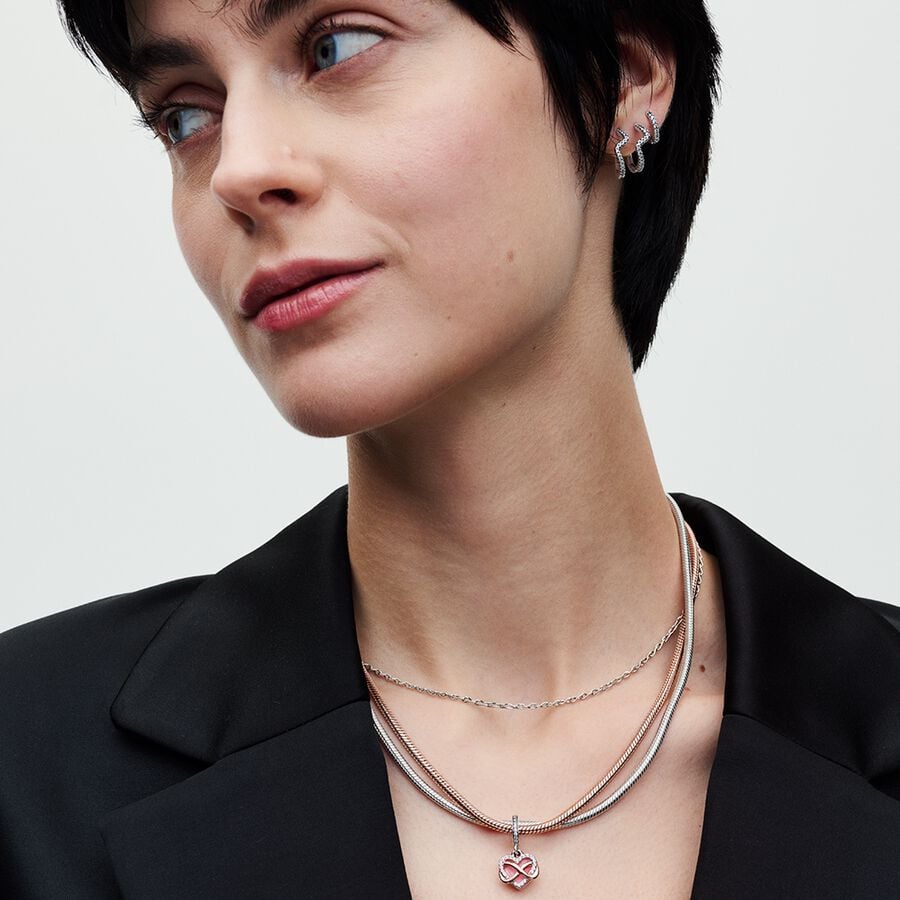 Mirdzošs piekarināmais sirsniņamulets ar bezgalības motīvu