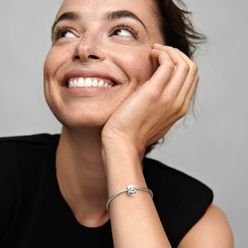 Tumsā spīdošs galvaskausa amulets