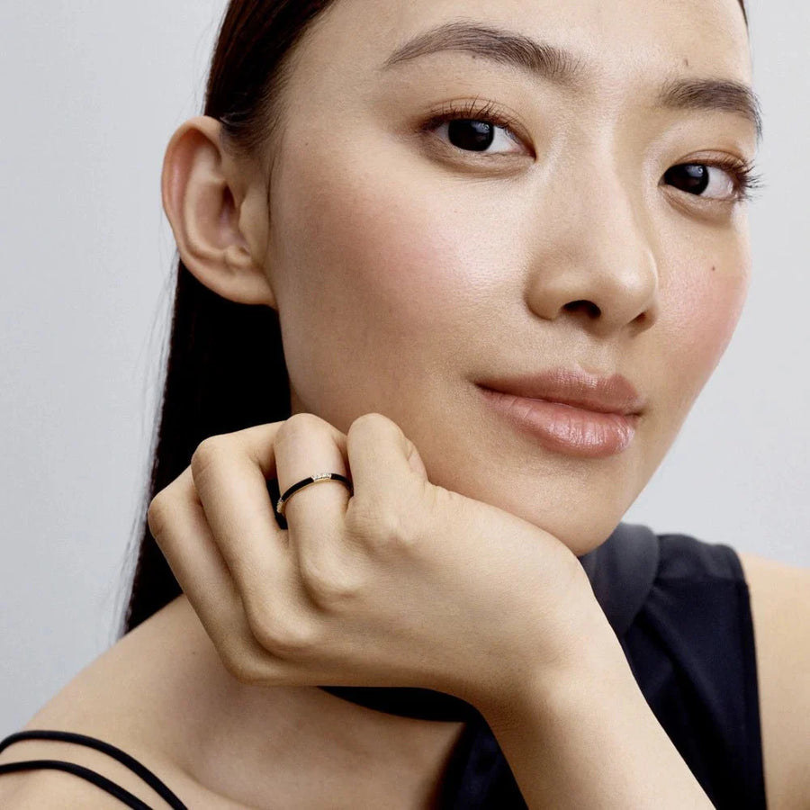 Melns emaljas un akmentiņu gredzens